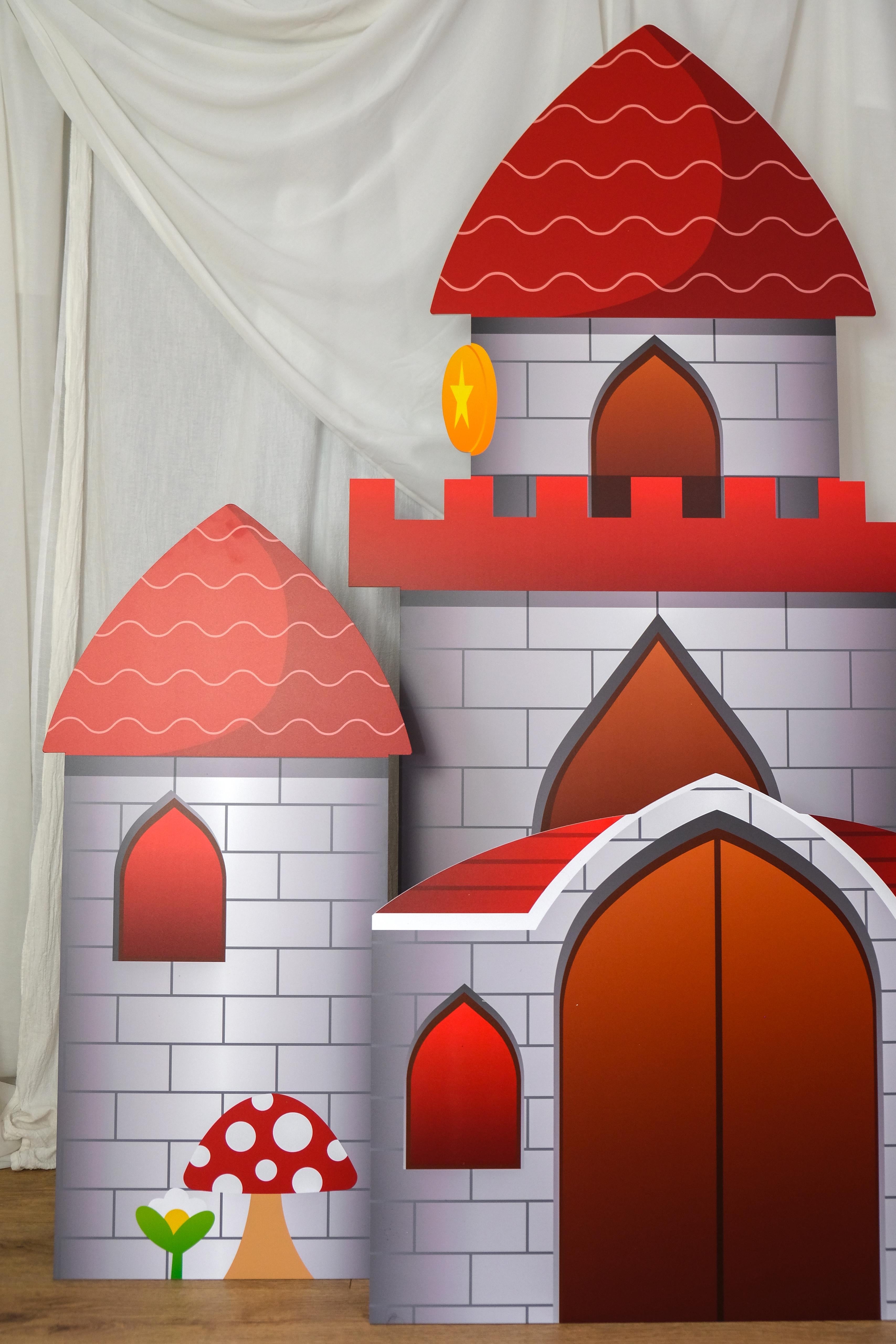 Side view of Gaming Castle waterproof foamex castle set showing middle tower with arched doorway, side towers with red roofs, and mushroom detail gaming party prop