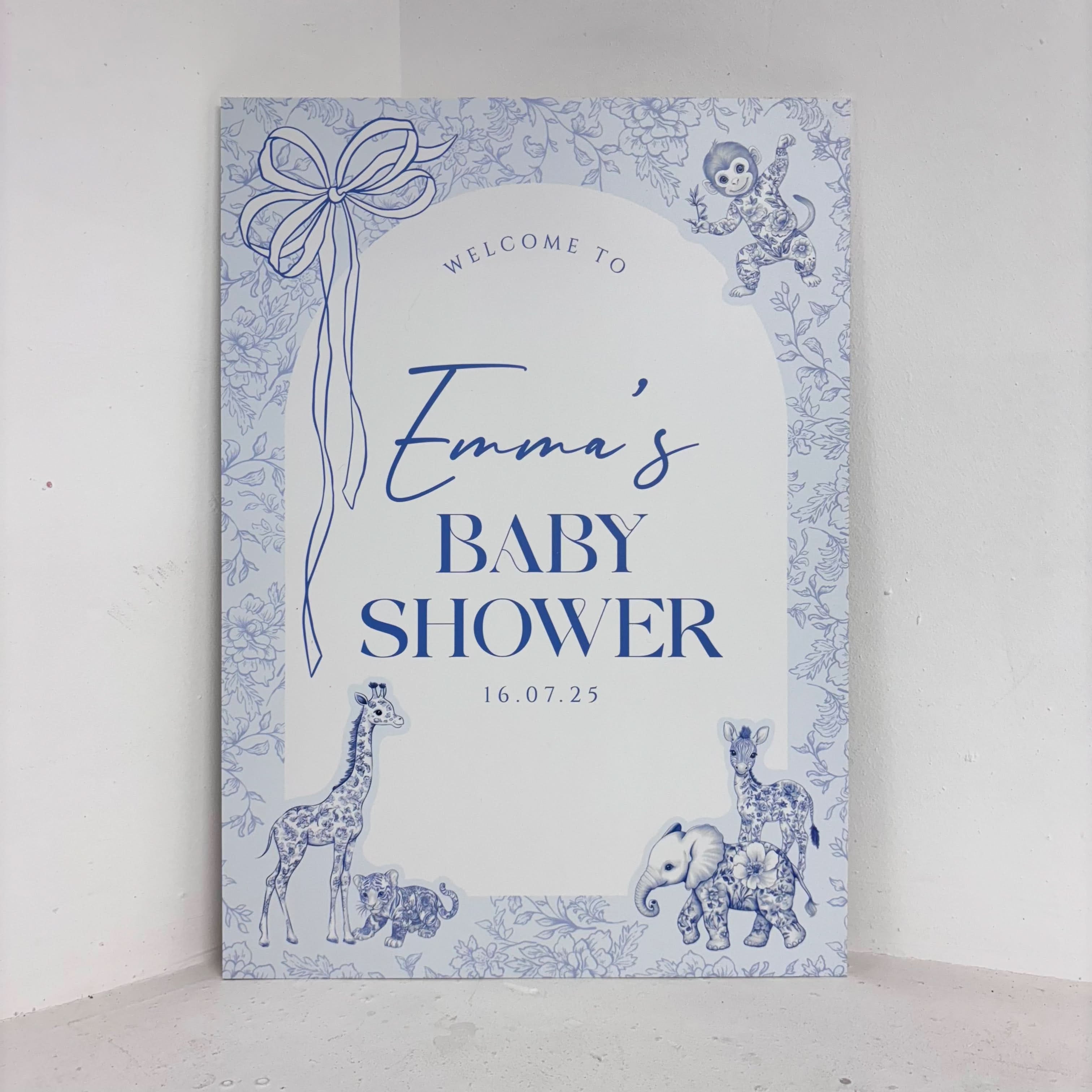 Toile Safari baby shower easel sign in blue with hand-drawn safari animal illustrations including giraffe, elephant, and monkey, personalised with name and date