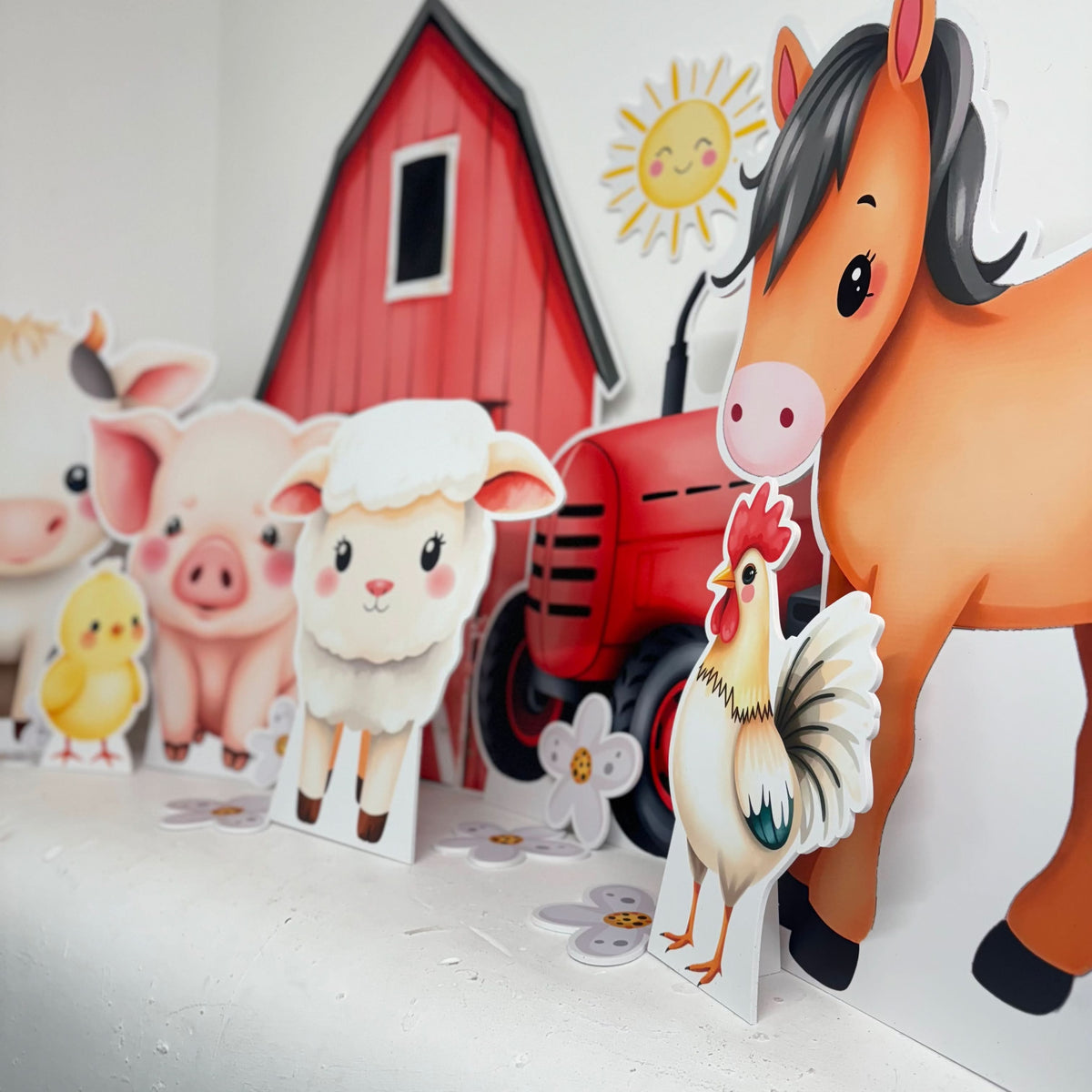 Close-up of On The Farm waterproof foamex cutouts showing horse, chicken, sheep, pig, and red tractor with barn and sun party decorations