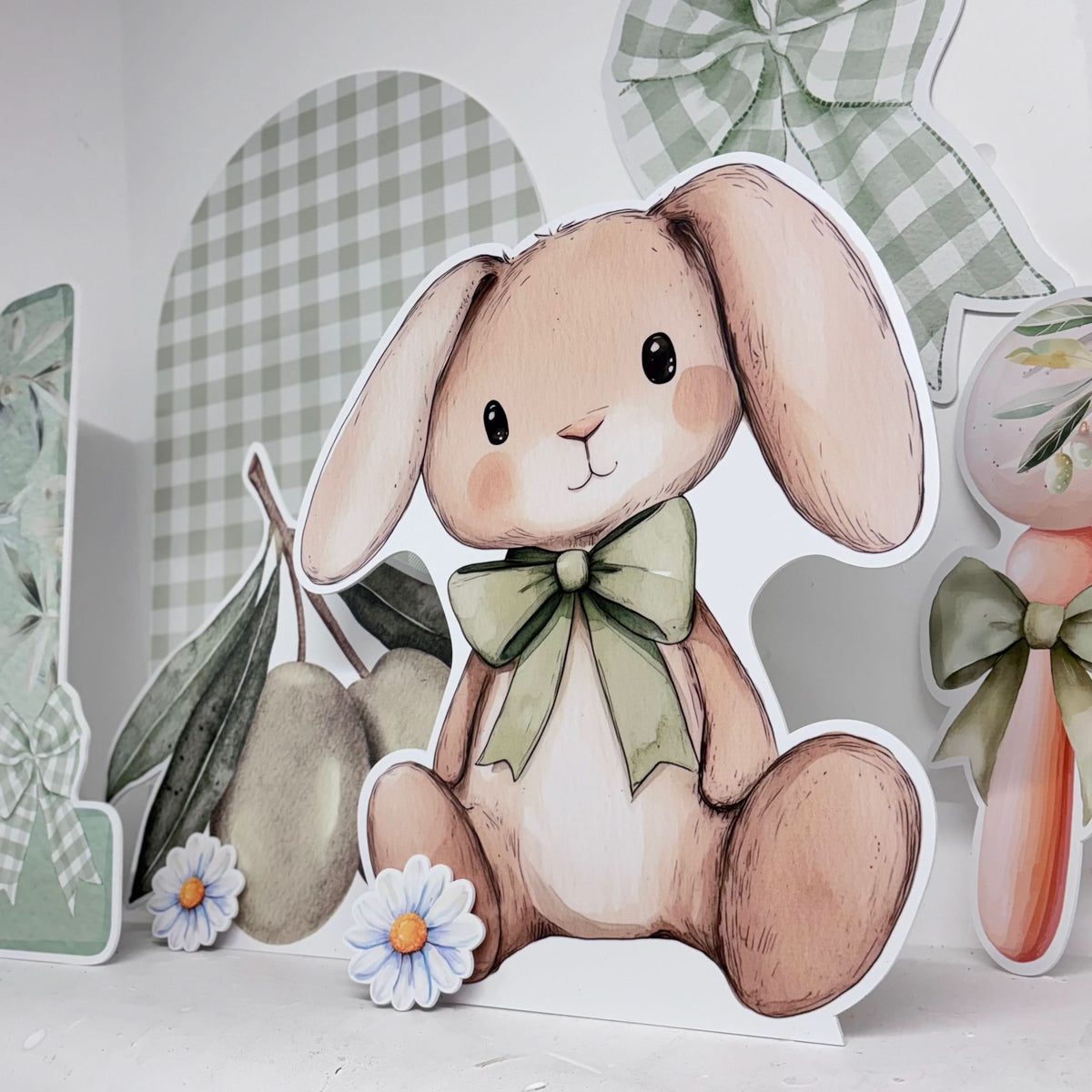 Close-up of I Olive You Bundle waterproof foamex cutouts showing bunny with green bow tie, daisies, olive branches, and green gingham sailboard first birthday party decorations