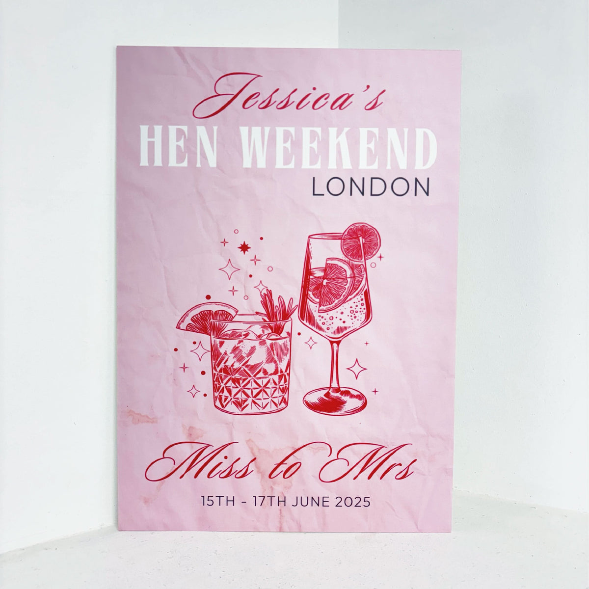 Hen Weekend easel sign in pink with cocktail illustrations, Miss to Mrs text, personalised with name, location, and dates for a hen party welcome display