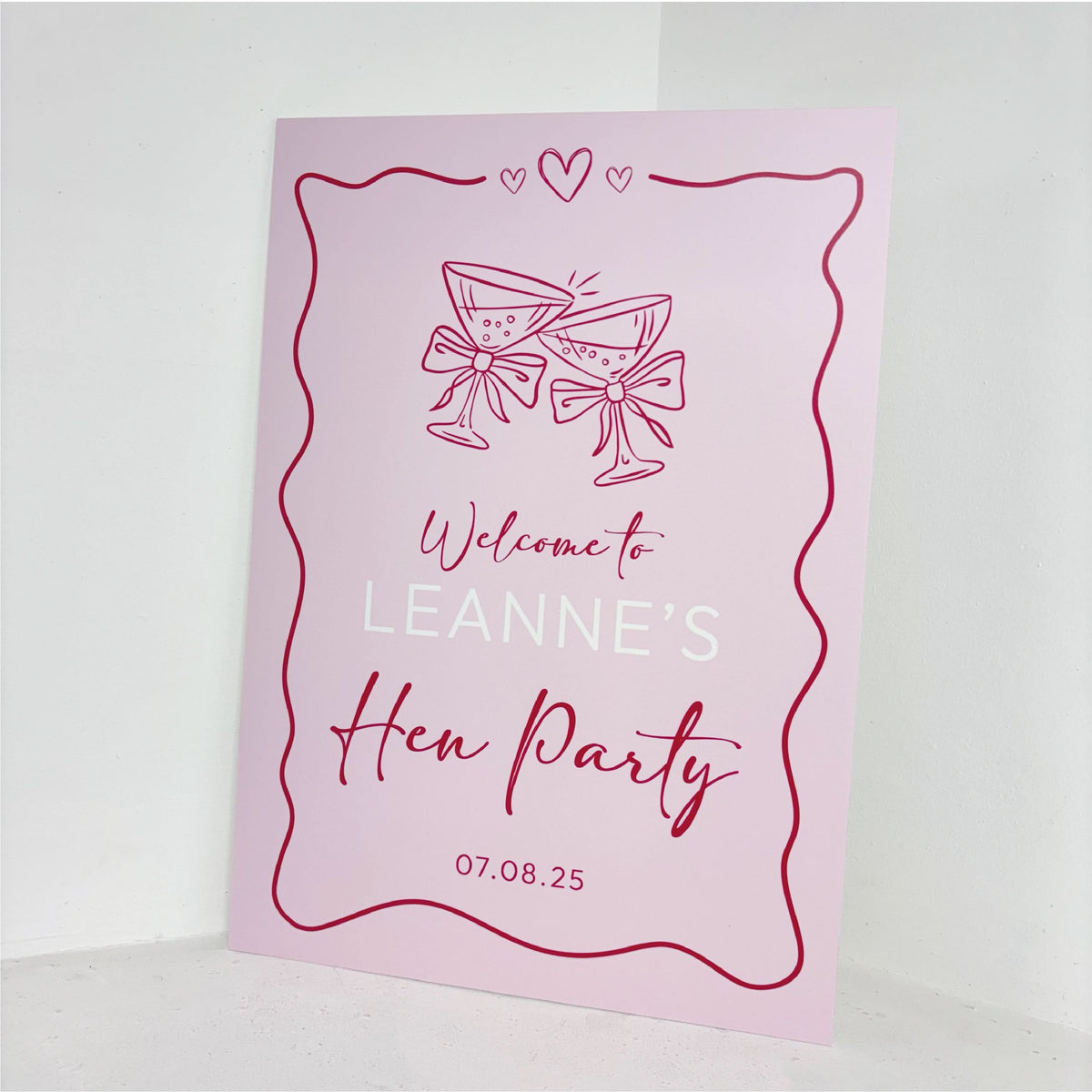 Close-up of Hen Party personalised welcome sign in pink with bow and cocktail details, custom name and date on waterproof foamex board
