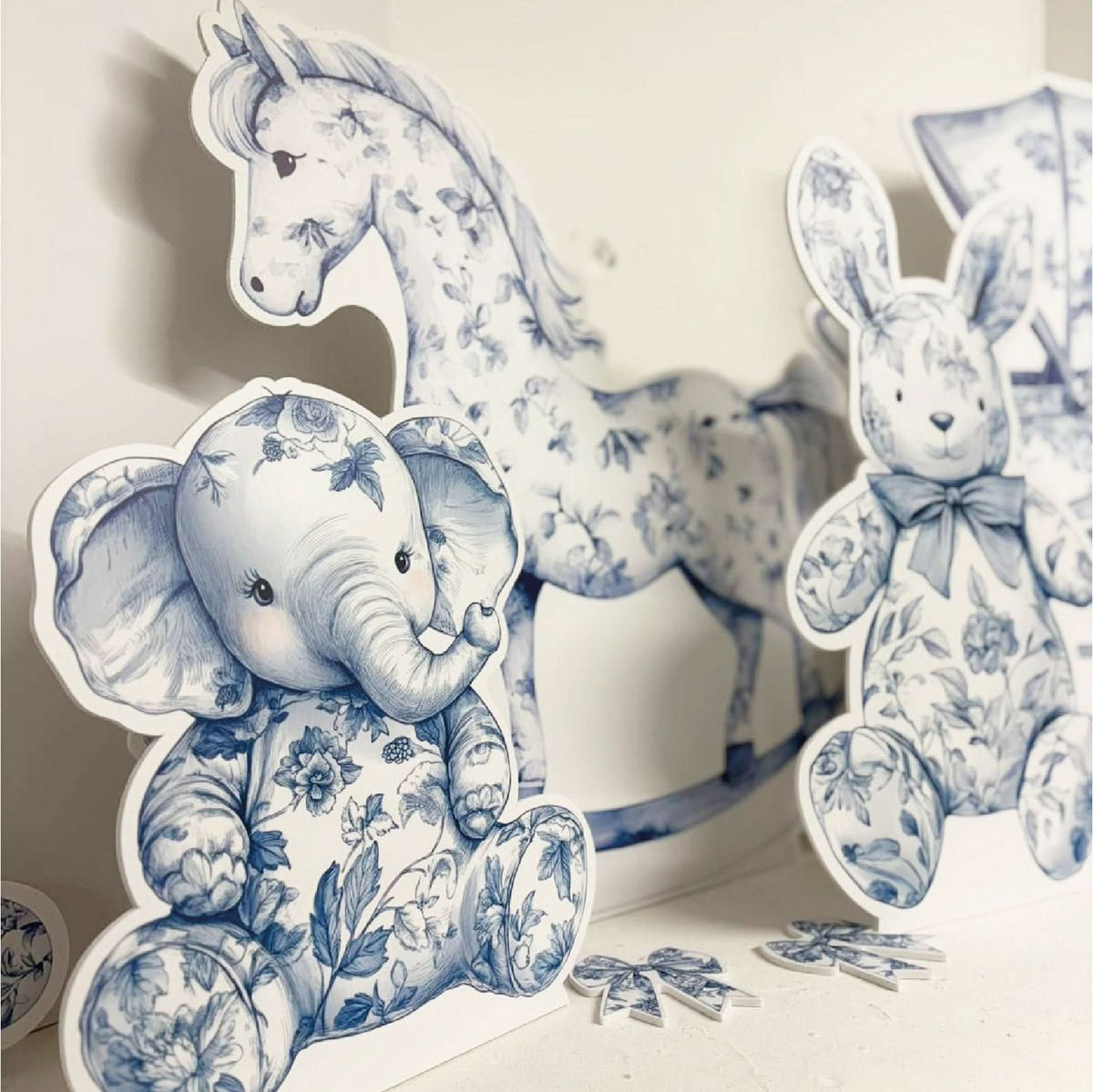 Close-up of Blue Baby Set waterproof foamex cutouts showing blue floral elephant, rocking horse, bunny with bow, and decorative flower baby shower party decorations