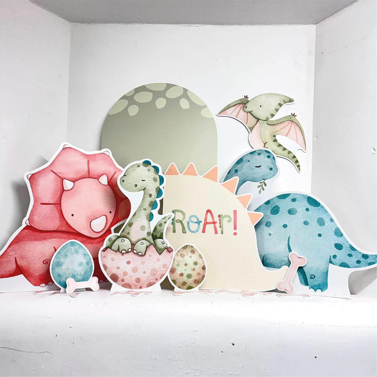 Roar Dinosaur Bundle featuring personalised waterproof foamex cutouts including pink triceratops, green brachiosaurus, blue dinosaur, pterodactyl, ROAR sign, dinosaur eggs, and sail board party decorations