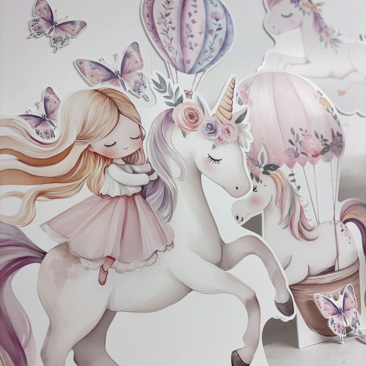 Close-up of Mini Floral Unicorn waterproof foamex cutouts showing blonde girl riding unicorn with butterflies, hot air balloon, and floral rose decorations