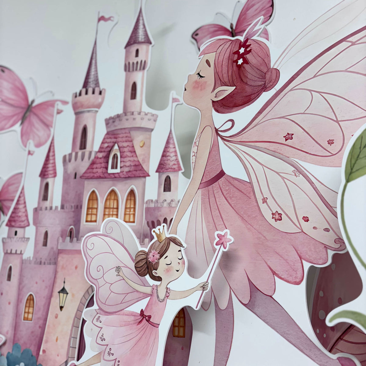 Close-up of Twinkle Fairies waterproof foamex cutouts showing fairy with wand and crown next to pink fairy castle with butterflies and star decorations