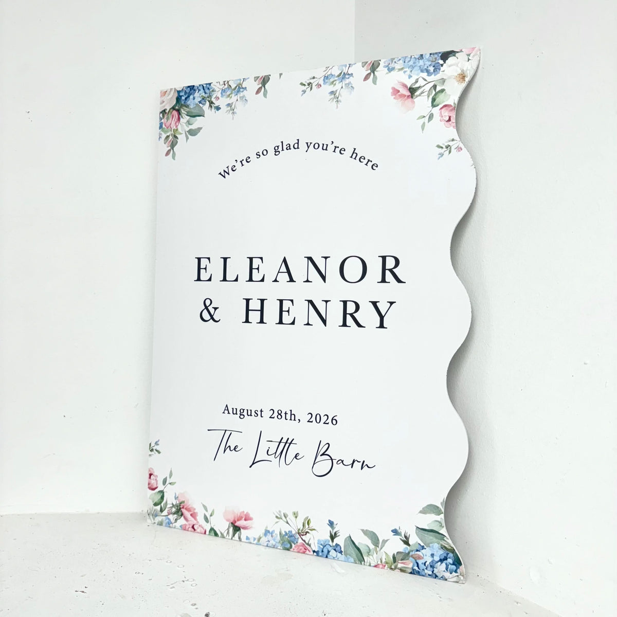 Close-up of Floral Wiggle personalised wedding easel sign showing customisable names, date and venue with elegant floral border on freestanding foamex board