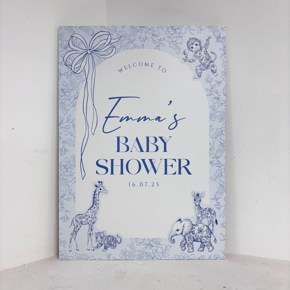 Toile Safari baby shower easel sign in blue with hand-drawn safari animal illustrations including giraffe, elephant, and monkey, personalised with name and date