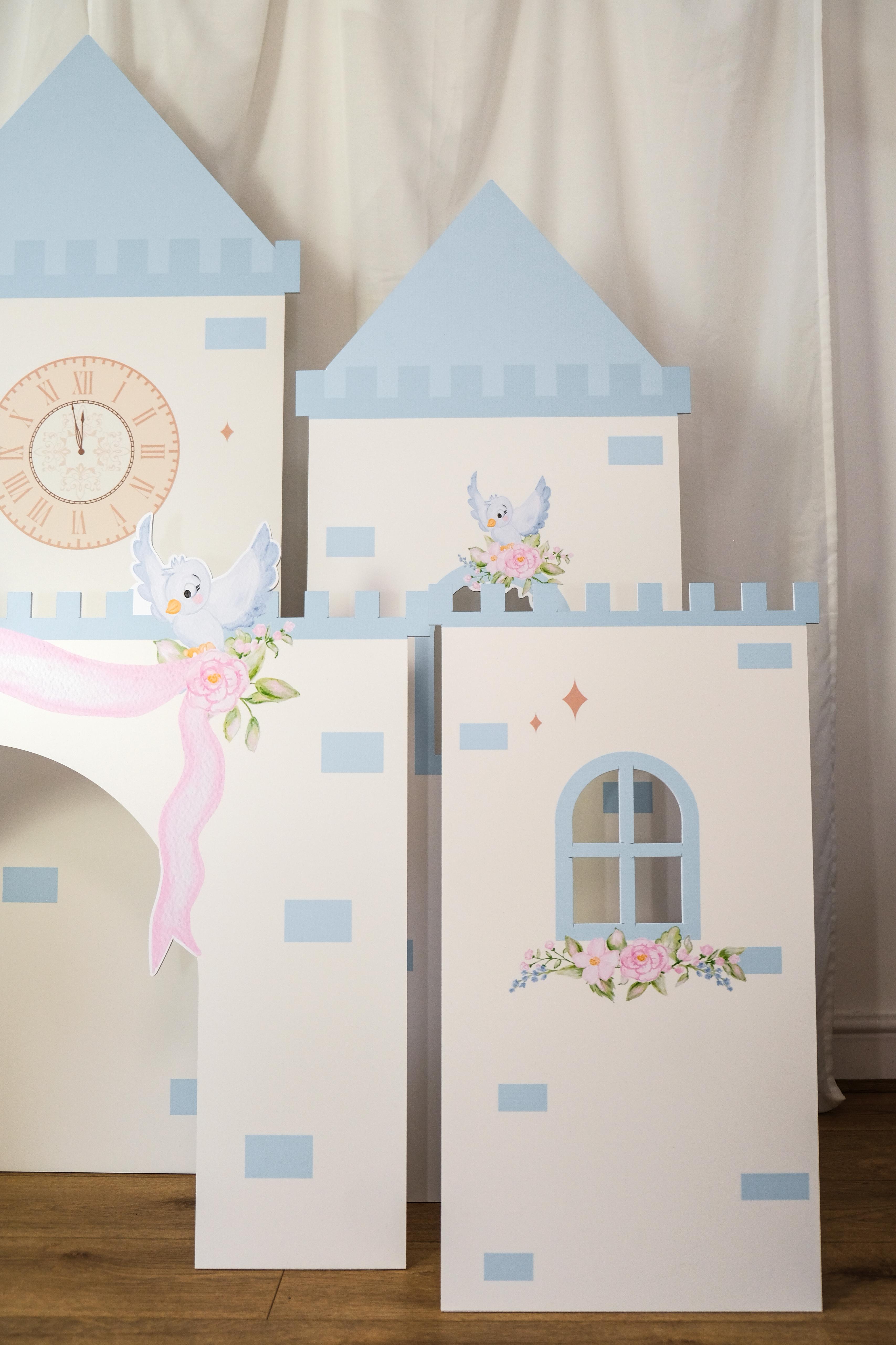 Side view of Midnight Castle waterproof foamex side towers with blue turrets, arched windows, rose decorations, and clock tower visible in background party prop