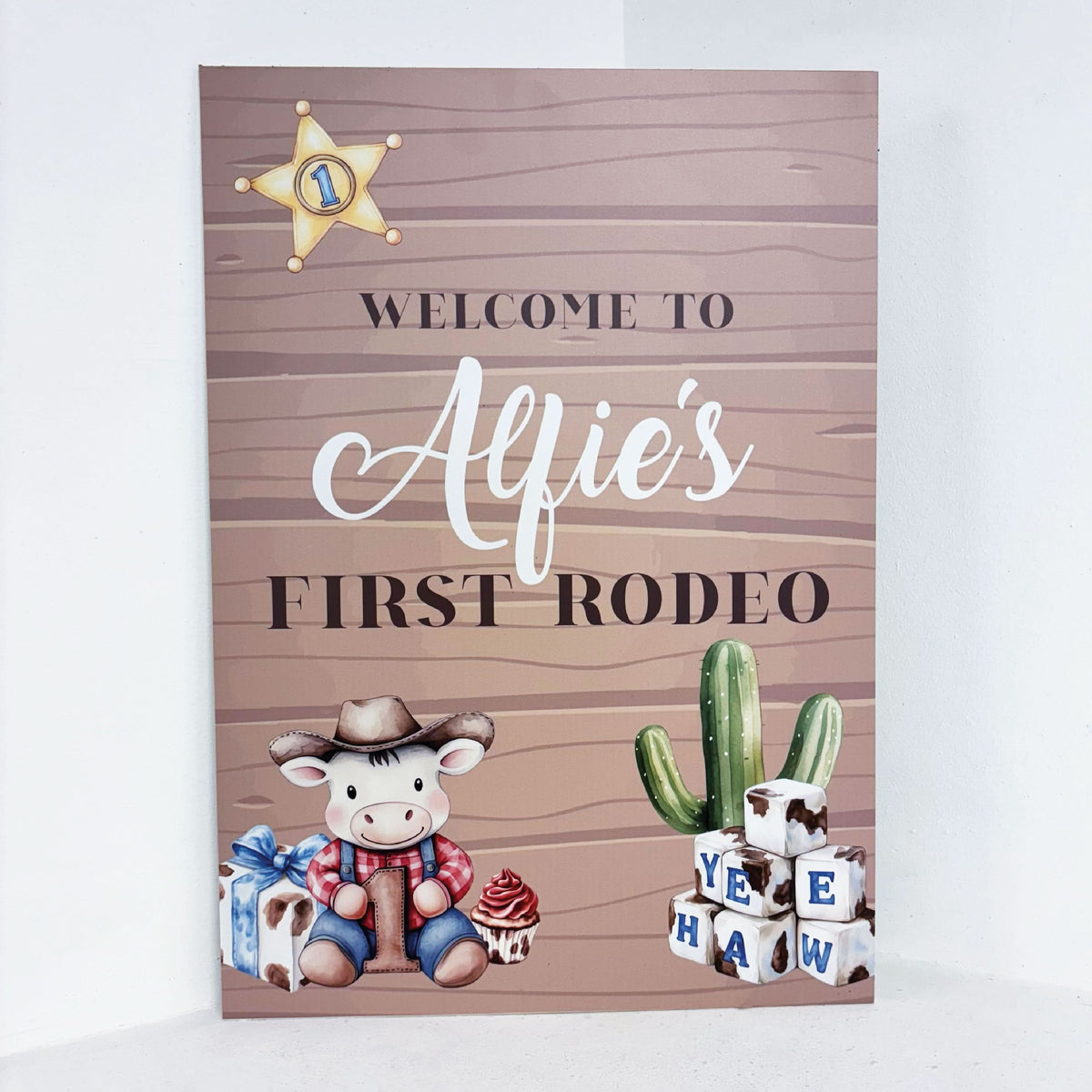 My First Rodeo personalised 1st birthday easel sign with cowboy theme, sheriff badge, cactus and custom name on wooden-effect waterproof foamex board
