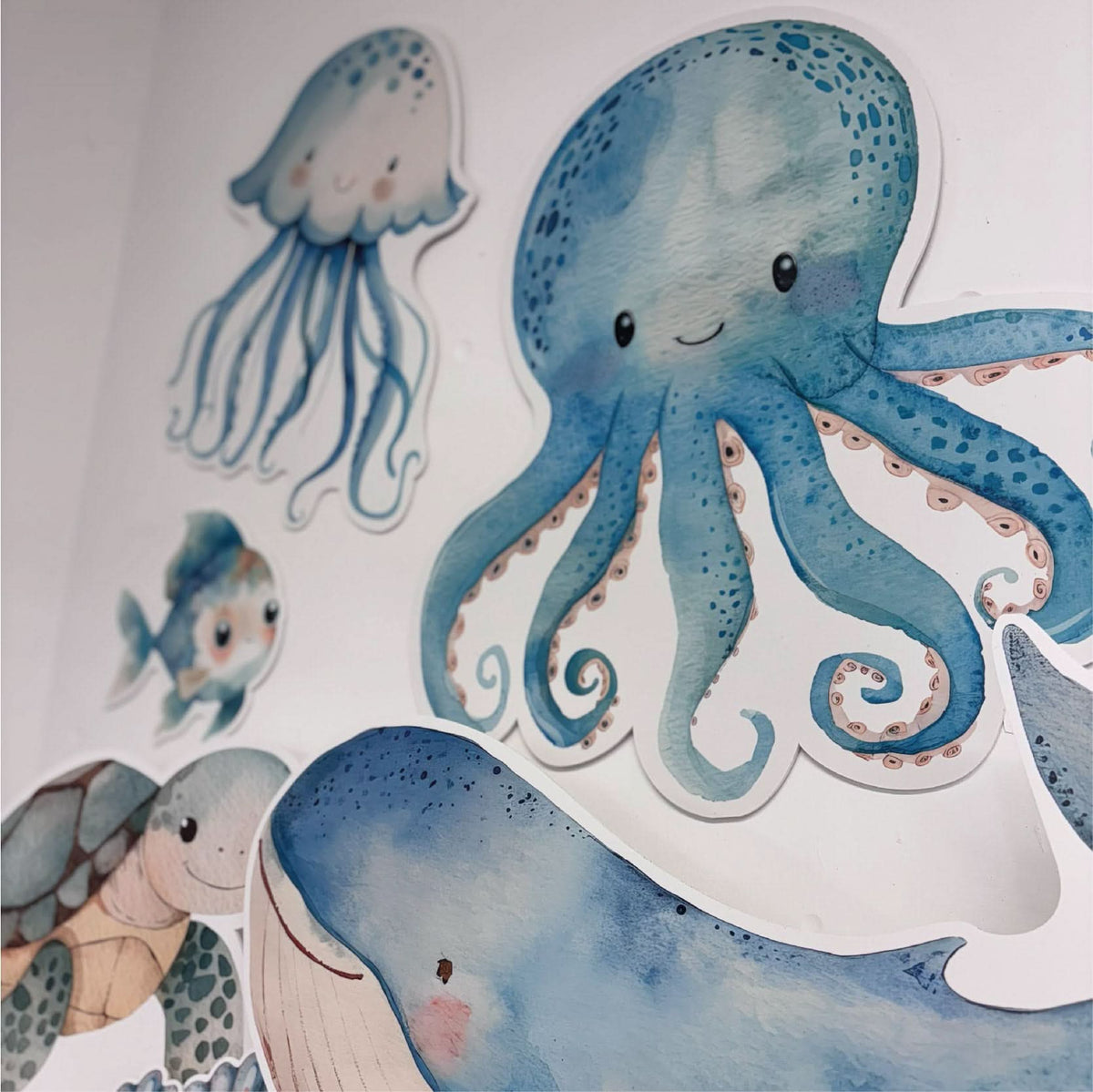 Close-up of Mini Under the Sea waterproof foamex cutouts showing octopus, jellyfish, whale, and turtle ocean themed party decorations