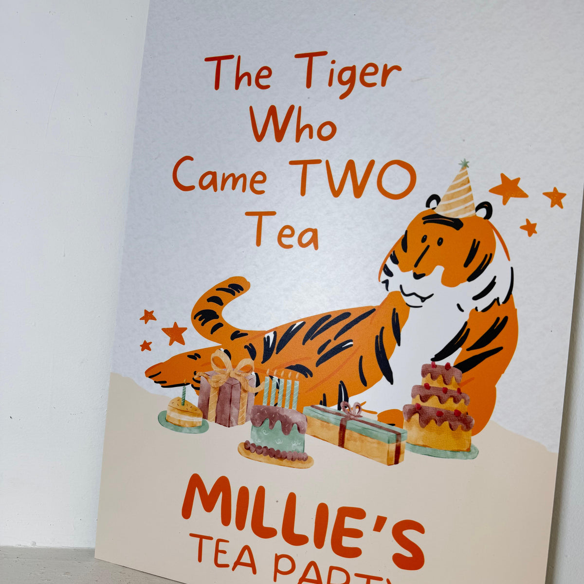 Close-up angled view of Tiger Two Tea 2nd birthday foamex easel sign showing personalised name and tea party cake illustrations